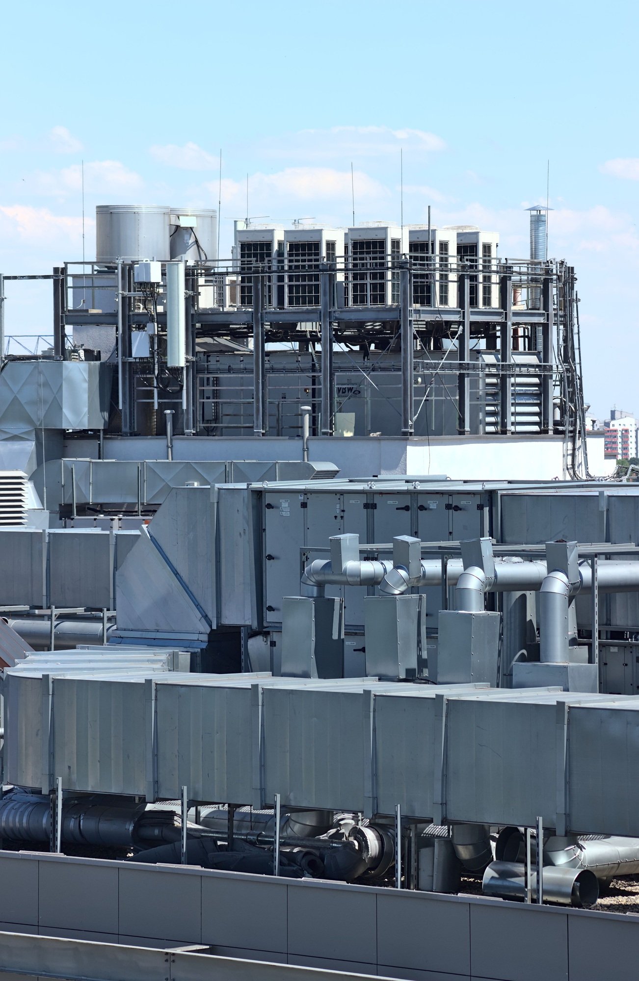 Vertical shot of a ventilation system of a building located on the roof against a blue sky